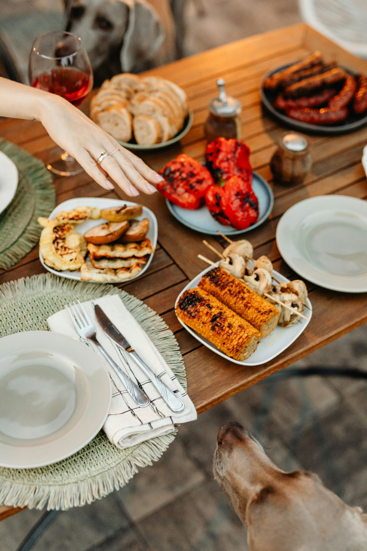 Outdoor table set with grilled corn and plates